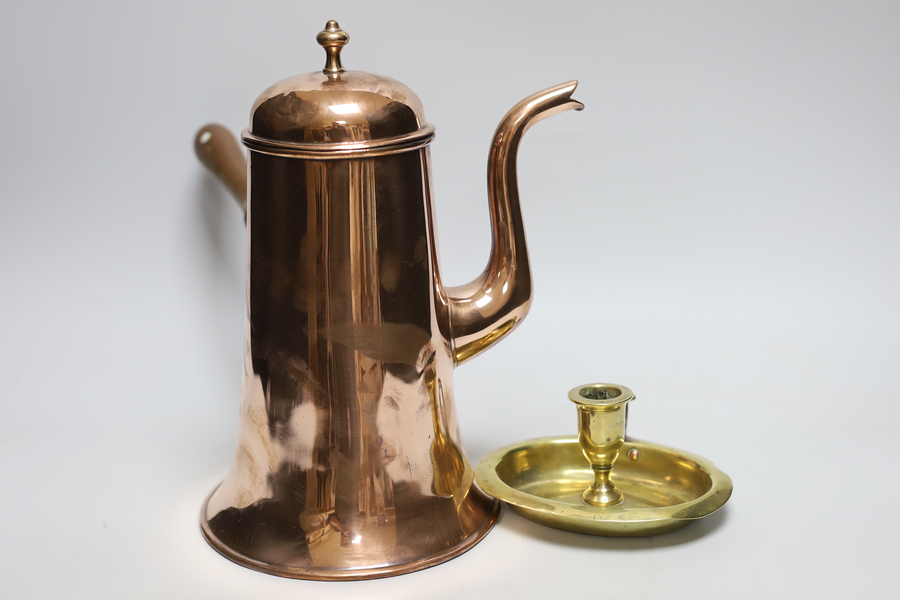 An 18th century copper chocolate pot and a brass chamberstick, tallest 28cm